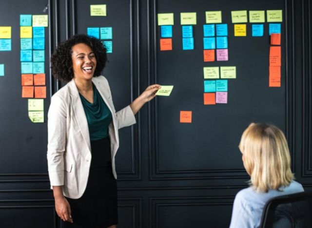 Stock Businesswoman smiling with post it notes 850x620